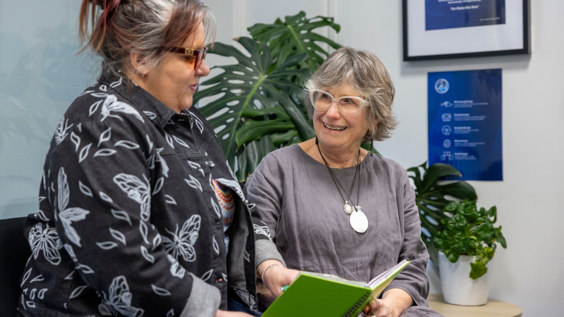 Leeann and Shona from APM NZ reading a book together