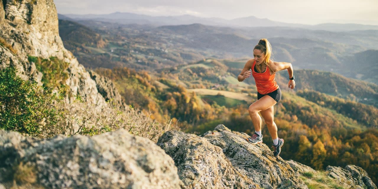 Woman running up hilly terrain