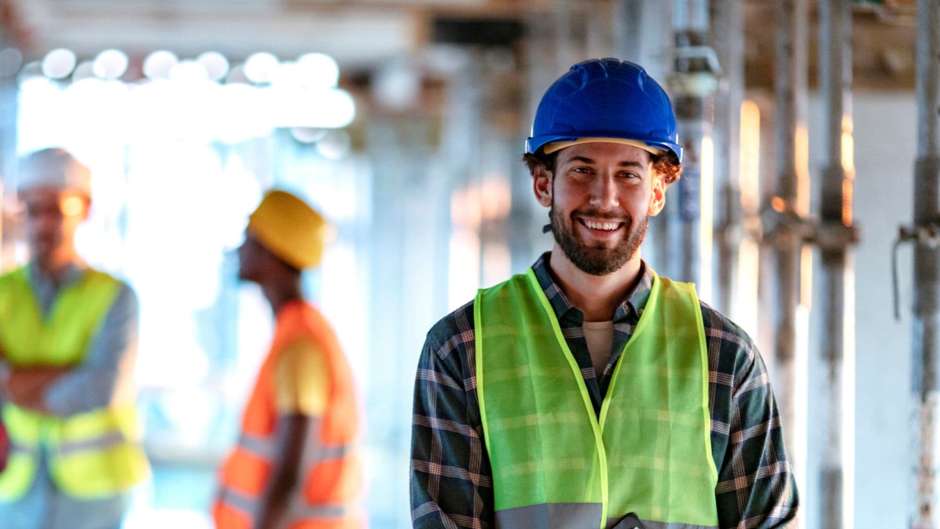 Worker in hard hat and high vis smiling