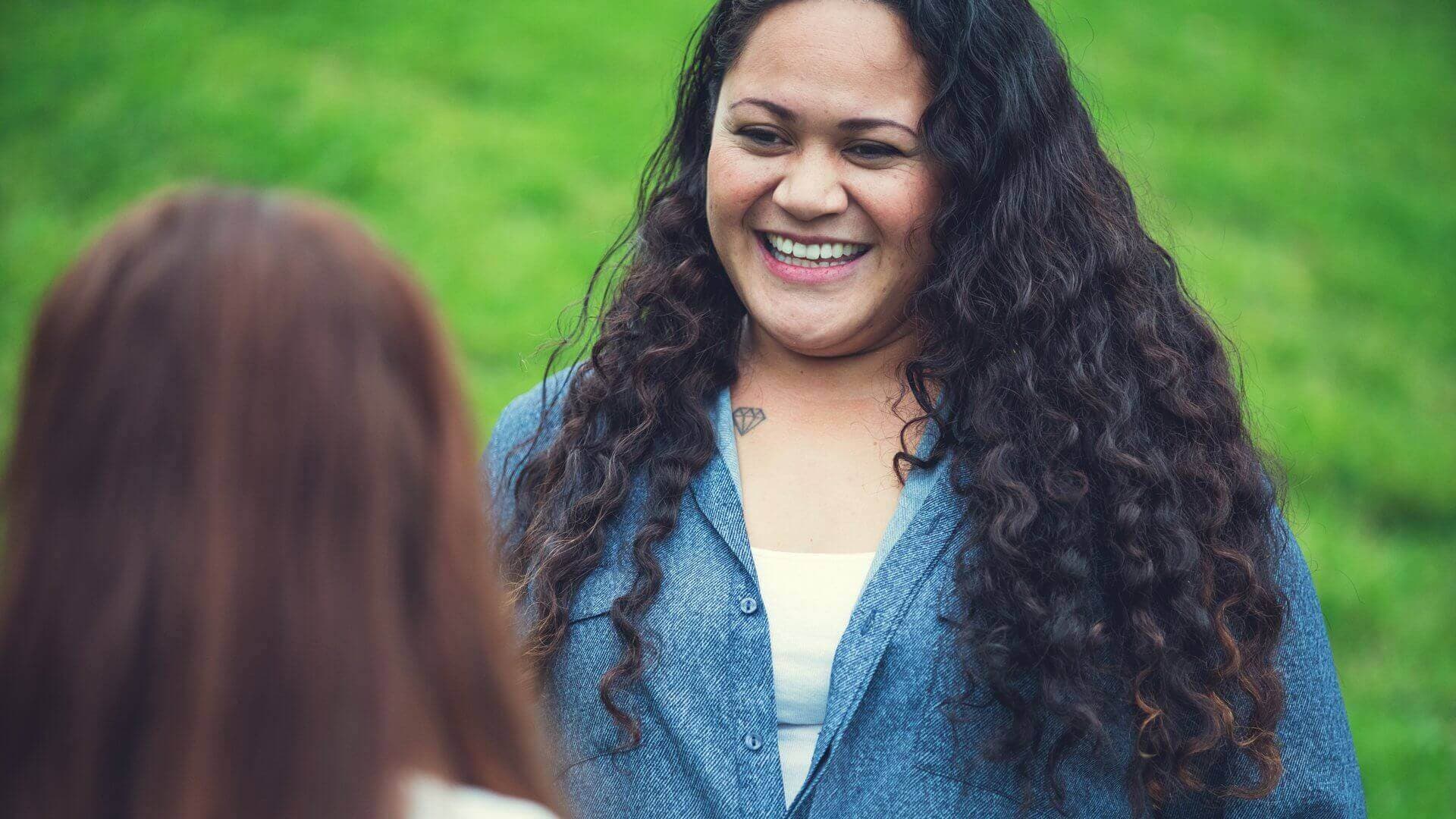 Maori woman talking to another woman outside