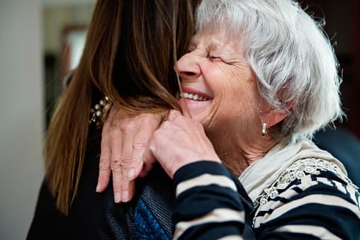 Older woman embraces her child merrily