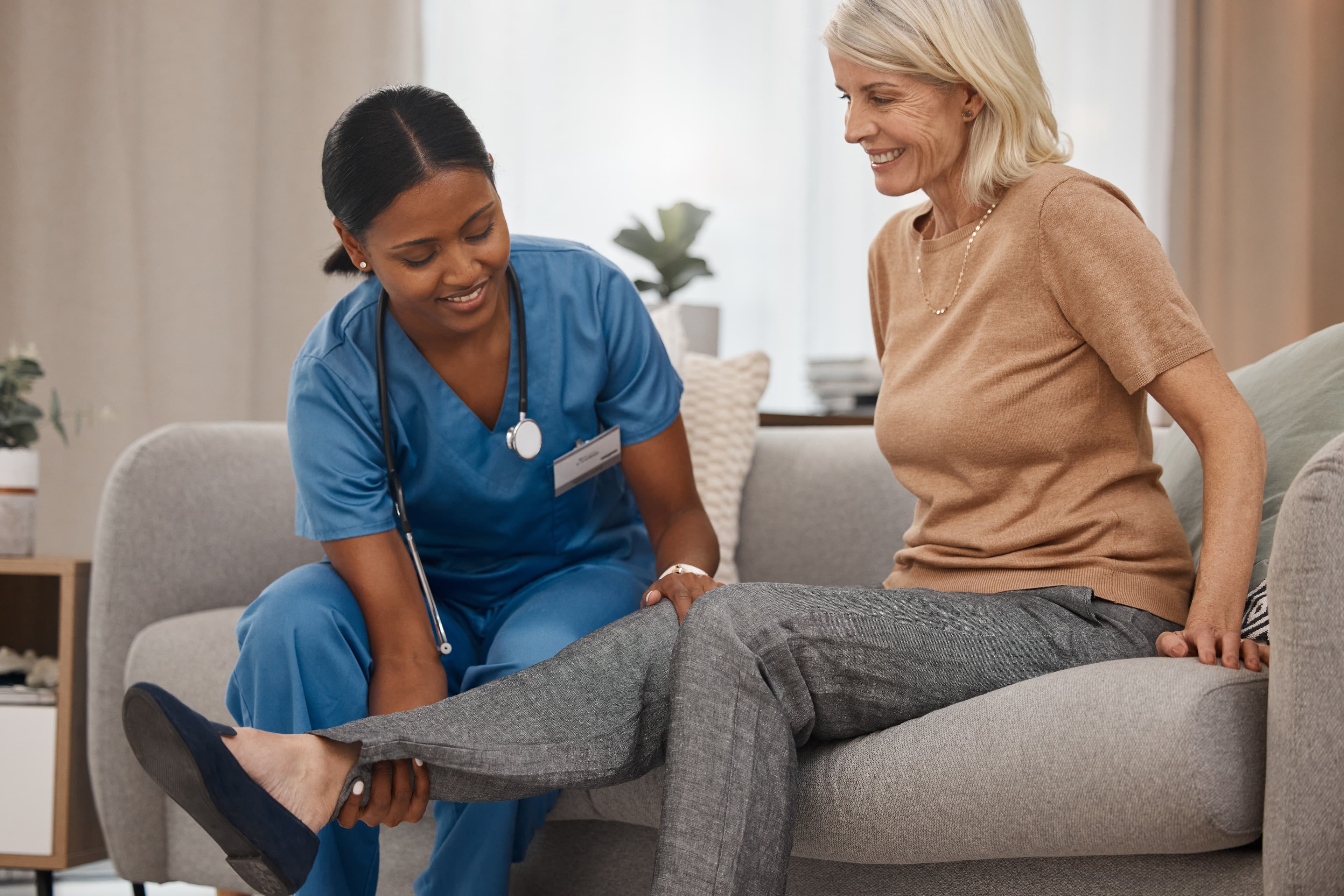 Physio lifts an older patient's leg